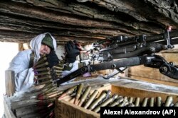 Український військовослужбовець перевіряє свій кулемет в укритті на передовій на сході України, 27 січня 2022 року
