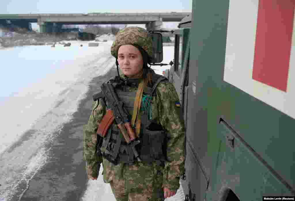 A 21 éves Násztya, az ukrán fegyveres erők orvosa egy katonai mentőautó mellett áll az oroszok által támogatott lázadók és az ukrán erők közti válaszvonal közelében a donyecki Piski falu előtt 2022. január 26-án