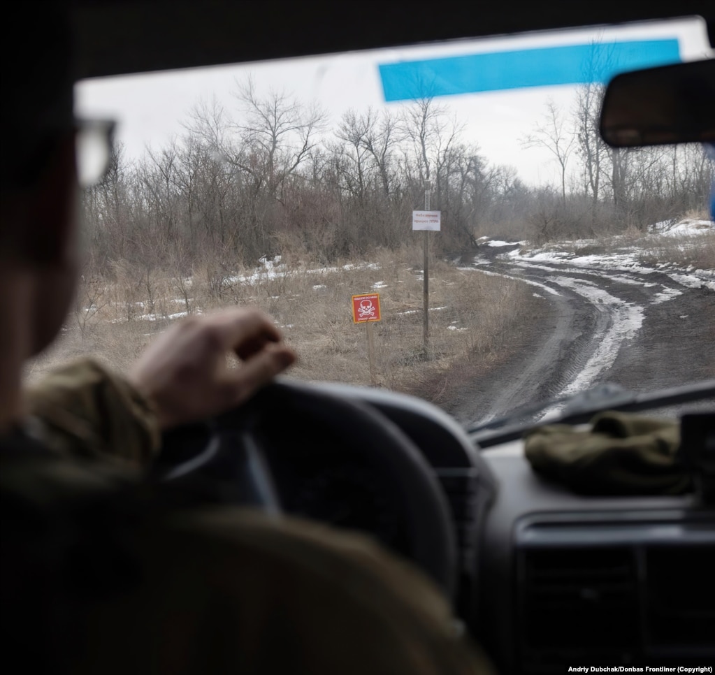 Një shenjë që paralajmëron për rrezikun e minave tokësore shihet nga një automjet pranë vijave të frontit, në lindje të Ukrainës, në fillim të janarit.