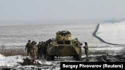 Военнослужащие российской армии рядом с бронетранспортером.