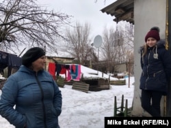 Svitlana Sukharevska and her 12-year-old daughter Arina stand in their backyard. The border with Russia is just 100 meters away.