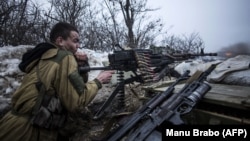 Un luptător separatists trage focuri de mitralieră împotriva pozițiilor armatei ucrainene din vecinătatea orașului Debalțeve, regiunea Donețk, 28 ianuarie 2022.