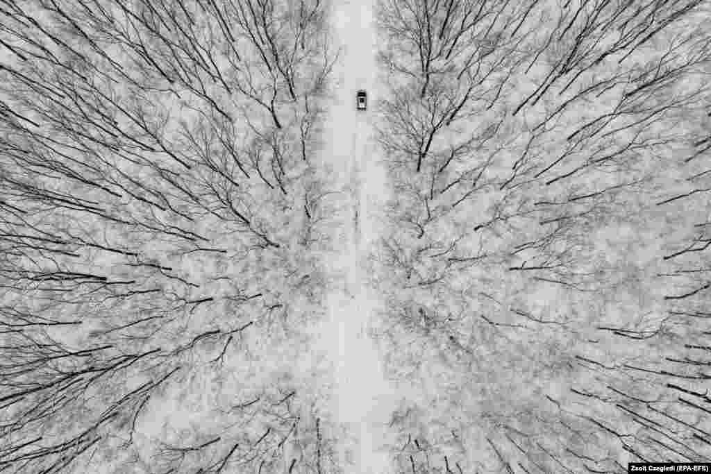 A drone photo shows a car driving through a snow-covered landscape near Debrecen, Hungary.