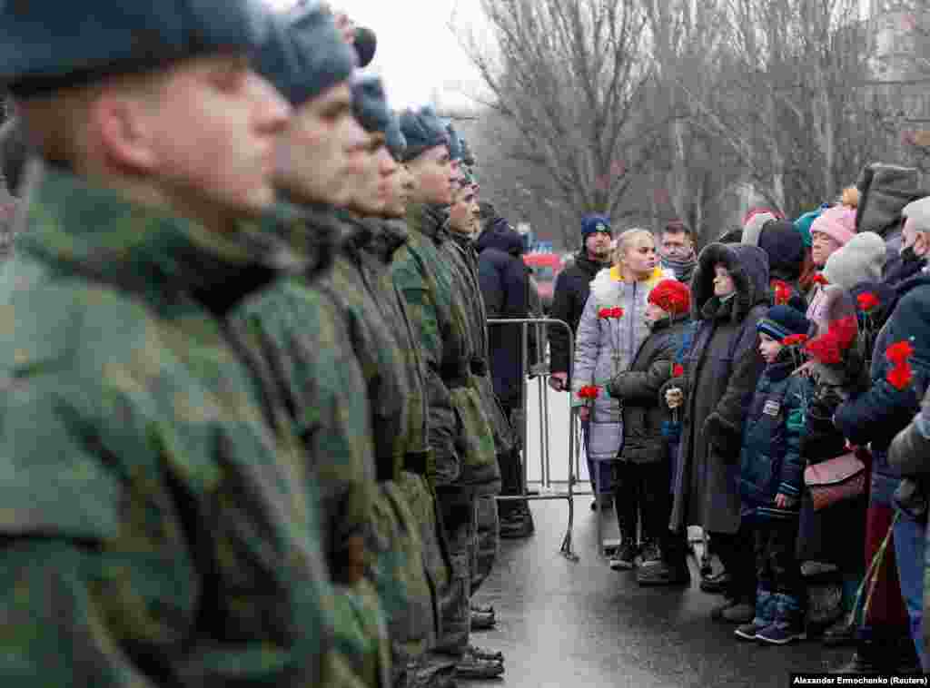 Helyi lakosok és kadétok az Oroszország által támogatott, magát Donyecki Népköztársaságnak nevező szakadár csoport által ellenőrzött régióban egy január 22-i megemlékezésen. 2015. január 22-én trolibuszban utazó civilek haltak meg egy bombatámadásban. Az esetért a két fél egymást hibáztatta