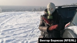 A resident of the Siberian city of Minusinsk dons a gas mask to protest air pollution caused by burning coal for heat in 2021.