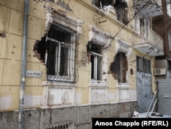 Artillery and bullet holes are visible on the outside of the former police headquarters in Mariupol.