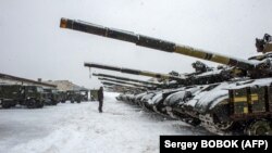 Військовослужбовець ЗСУ стоїть перед танками 92-ї окремої механізованої бригади, Харківська область, 31 січня 2022 року