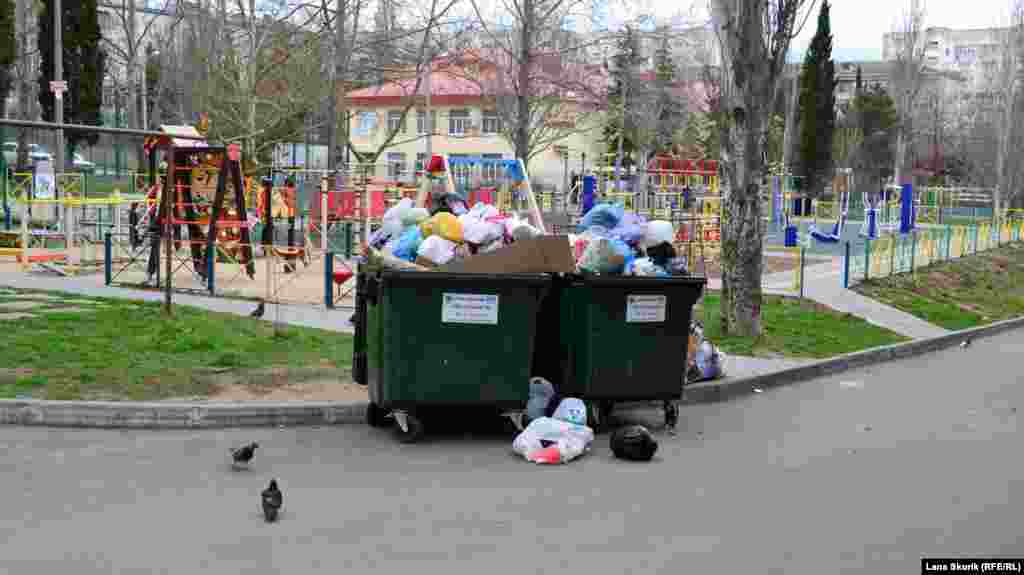 Во дворе этого же дома у детской и спортивной площадок &ndash; переполненные контейнеры для мусора