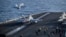 This US Navy handout photo released on May 12, 2026, by US Central Command Public Affairs shows an F/A-18E Super Hornet, attached to Strike Fighter Squadron 151, and an EA-18G Growler, attached to Electronic Attack Squadron 133, launching from the flight 