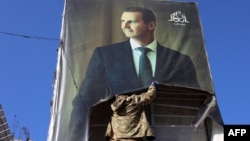 Hökumət əleyhdarı döyüşçü Hələbdə Suriya prezidenti Bəşər əl-Əsədin portretini cırır.