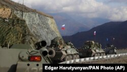 Russian military vehicles roll along a road towards Nagorno-Karabakh, November 13, 2020.