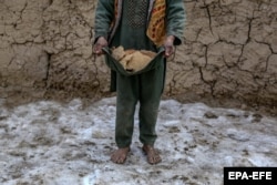 A barefoot boy carries bread home in Kabul.