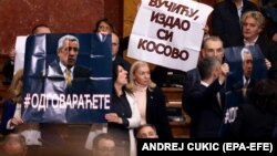 Members of the Serbian parliament hold up a banner reading, "Vucic, you betrayed Kosovo," during a special session in Belgrade on February 2.