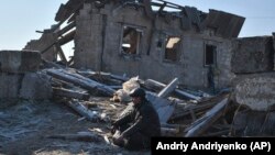 Місцевий житель сидить біля руїн свого будинку, зруйнованого ракетним обстрілом Росії в Запоріжжі, Україна, 26 січня 2023 року