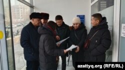 Люди, пришедшие в прокуратуру Алматы, собирают подписи к петиции с требованием отставки генпрокурора. 23 января 2022 года