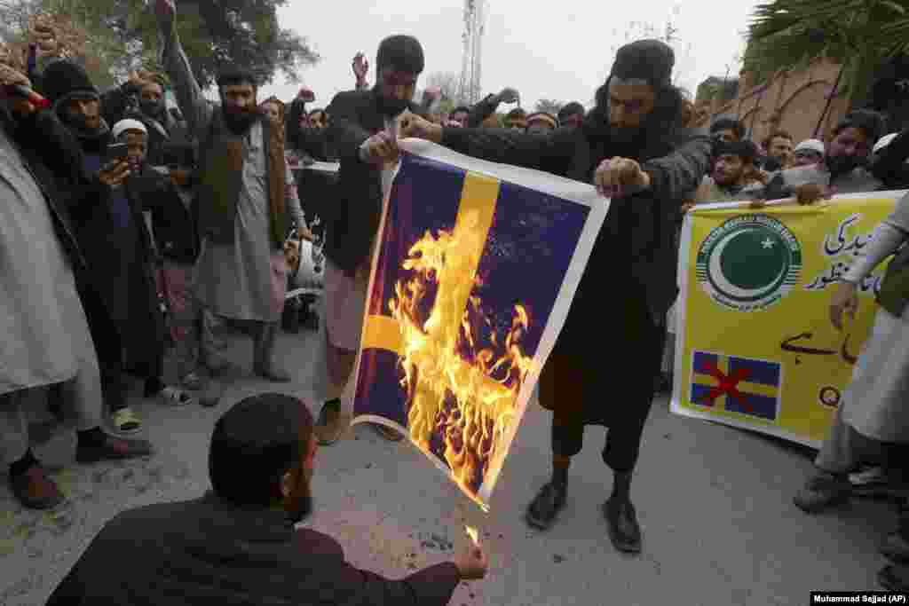 Supporters of the Pakistan Markazi Muslim League party burn a Swedish flag during a demonstration against the burning of the Koran by a Danish anti-Islam activist, in Peshawar on January 24.