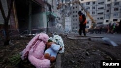 Tributes are left at an apartment block that was heavily damaged by a Russian missile strike, killing dozens inside, in Dnipro on January 16. 