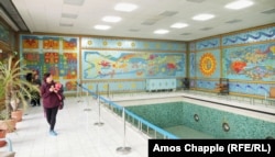 Туристи разглеждат басейна в имението Чаушеску в Букурещ. Стените са украсени с мозайки, направени през 60-те години на миналия век.
