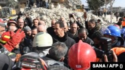 Sirijski predsjednik Bašar al-Asad pozdravlja ljude dok posjećuje kvartove pogođene zemljotresom u sjevernom gradu Alepu, 10. februara 2023.