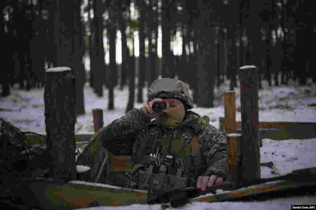 A Ukrainian soldier looks out from his position toward the Belarus border on February 1. Concerns of a renewed military push heightened in January after Russia and Belarus held joint air force drills, one month after a rare visit by Russian President Vladimir Putin to Minsk.&nbsp;Belarusian officials attribute the troop deployment along the border to &ldquo;strategic deterrence.&rdquo;