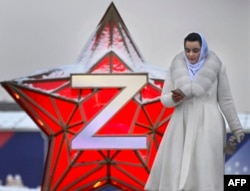 Человек идёт мимо новогодней звезды с буквой Z возле парка Горького в Москве, 29 декабря 2022