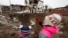 Діти стоять біля воронки, утвореної російським ракетним ударом під час атаки Росії на Україну, у місті Глеваха, під Києвом, 26 січня 2023 року. Фото ілюстративне 