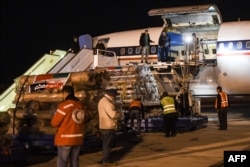  Работници разтоварват помощ, изпратена от Иран със аероплан, на летището в северния сирийски град Алепо, 8 февруари 2023 година 