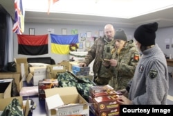 Militari sosiți de pe front, colectează pachetele pregătite de „Mișcarea femeilor veterane”, care includ și produse specifice pentru femei.