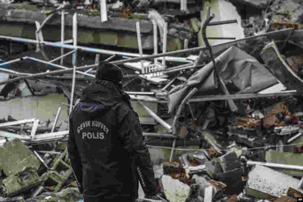 Një oficer policie pranë një ndërtese të shkatërruar në Gaziantep, Turqi. Tërmeti i fuqishëm ka rrëzuar shumë ndërtesa në Turqinë juglindore dhe në Siri dhe dyshohet për mijëra viktima.