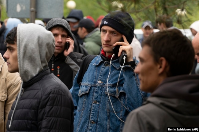 Russian men line up to get Kazakh registrations after crossing the border into Kazakhstan from the Mariinsky border crossing on September 28, 2022.