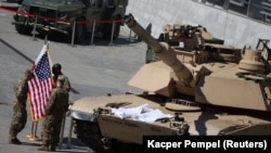 Soldați americani lângă un tanc M1/A2 Abrams la cea de-a 30-a Expoziție internațională a industriei de apărare din Kielce, Polonia, 5 septembrie 2022