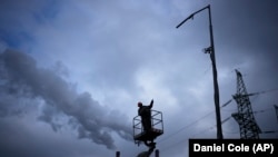 An electrician checks damage at a power plant after a rocket attack in Kyiv on January 26.