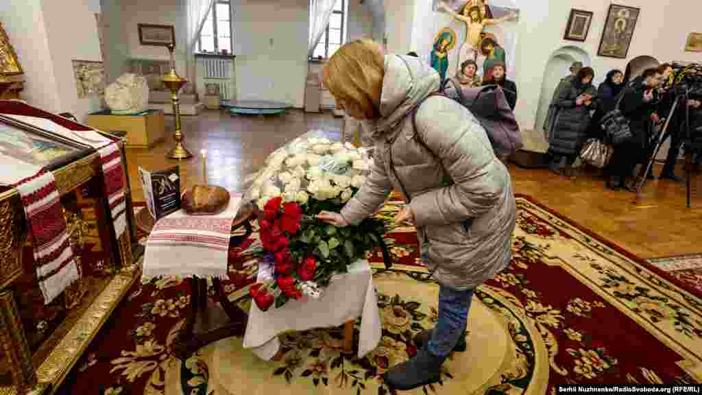 Присутні символічно покладають квіти до фотографії Енді