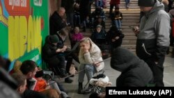 İnsanlar Kiyevdə raket hücumu zamanı bomba sığınacağı kimi istifadə edilən metro stansiyasına toplaşıblar.
