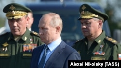 Presidenti rus, Vladimir Putin, i rrethuar nga gjenerali, Valery Gerasimov, (majtas) dhe ministri i Mbrojtjes, Sergei Shoigu.