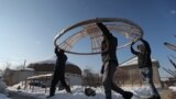 This February 1 photo shows Kazakh volunteers carrying a &quot;tunduk,&quot; the central portal of a yurt, towards a truck being filled with supplies for Ukraine. The men are preparing the aid shipment in the village of Qainazar, just east of Almaty.