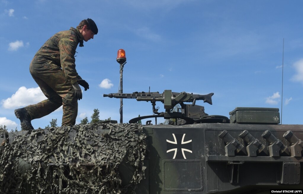 Një ushtar gjerman duke ecur mbi një tank të llojit Leopard, gjatë stërvitjeve të NATO-s, në jug të Gjermanisë, më 2017.
