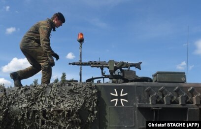 Një ushtar gjerman duke ecur mbi një tank të llojit Leopard, gjatë stërvitjeve të NATO-s, në jug të Gjermanisë, më 2017.