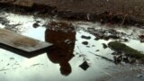 Srebrenica, Bosnia and Herzegovina -- Reflection of a man in a puddle of renowned Guber water from Srebrenica