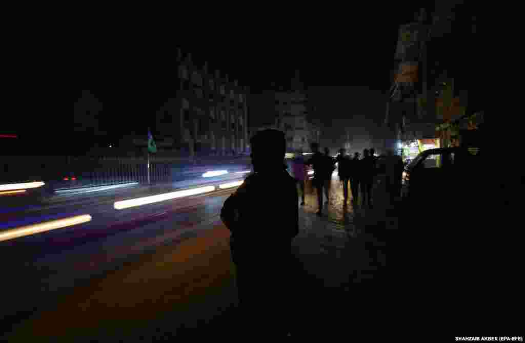 People are silhouetted against passing cars in Karachi. Talks are under way with the International Monetary Fund (IMF) to soften some conditions on Pakistan&rsquo;s $6 billion bailout, which the government thinks will trigger further inflation hikes. The IMF released the last crucial tranche of $1.1 billion to Islamabad in August. &nbsp;