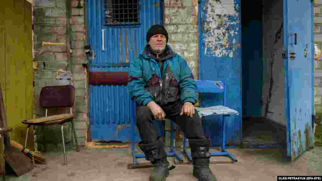 Volodimir üldögél lakóházuk bejárata mellett, amelynek pincéjében él három szomszédjával együtt a háború kitörése óta. Ideje nagy részét favágással tölti, hogy legyen elég fa a fűtéshez és a főzéshez