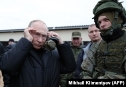 Russian President Vladimir Putin meets soldiers during a visit to a military training center for mobilized reservists outside the town of Ryazan on October 20, 2022.
