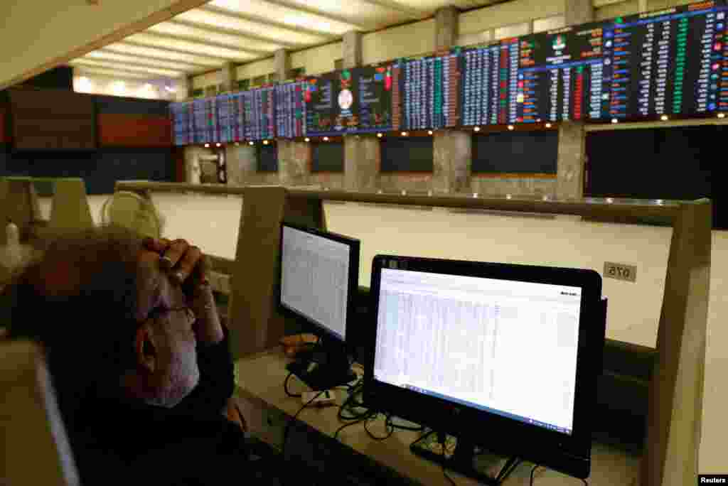Poduzeća, industrije i domovi često imaju vlastite generatore koji se uključuju kada nestane struje. na fotografiji: broker prati cijene dionica na računalima, napajanim agregatorom, u dvorani pakistanske burze (PSX) u trenucima nestanka struje u cijeloj zemlji, Karači.
