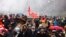 Протестиращи държат плакат с надпис "Незабавно пенсиониране за Макрон" по време на демонстрация в третия ден от националните митинги, организирани от началото на годината, срещу пенсионната реформа. Тулуза, Югозападна Франция, 7 февруари 2023 г. 
