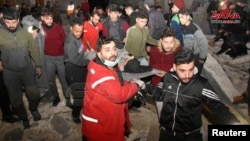  Спасители носят човек на носилка на мястото на срутена постройка след земетресение в Хама, Сирия, 6 февруари 2023 година 