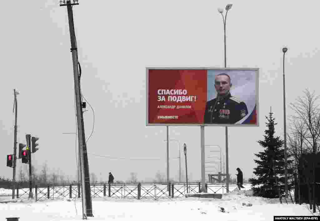 People walk past a propaganda billboard in St. Petersburg extolling the actions of Russian soldiers taking part in their country&#39;s unprovoked invasion of Ukraine.&nbsp;