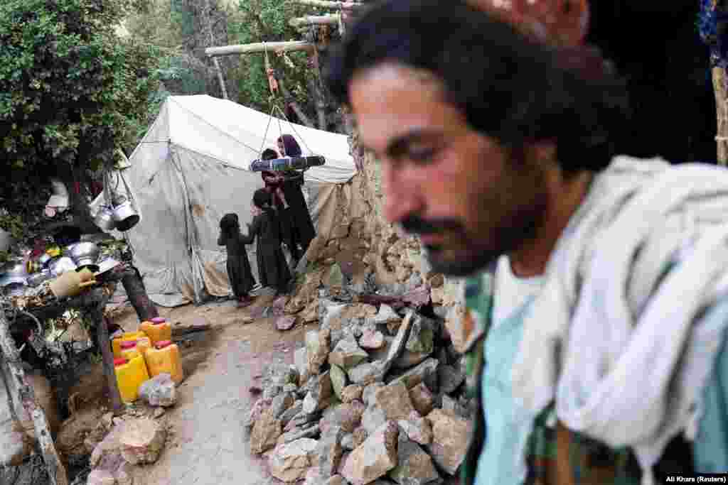 Авганистанци во област погодена од земјотрес во провинцијата Хост, Авганистан, на 26 јуни 2022 година. Во земјотресот со јачина од 6,1 степен на 22 јуни загинаа повеќе од 1.100 луѓе. &nbsp;
