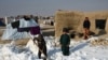Fëmijët në një kamp për të zhvendosurit brenda vendit (PZHBV) shihen duke hequr borën pranë tendave të tyre në distriktin Nahr-e-Shahi të provincës Balkh, afër Mazar-i-Sharif, më 17 janar. Në Kabul dhe disa provinca të tjera janë shënuar temperatura rekord të ulëta prej minus 33 gradë celsius, që nga 10 janari.<br />
&nbsp;