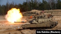 Tanket e llojit M1 Abrams duke shtënë gjatë manovrave ushtarake të NATO-s, në Letoni, më 2021.