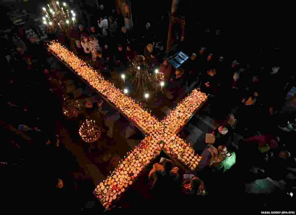 Orthodox faithful light candles with jars of honey during a holy mass for the Sanctification of Honey at the Presentation of the Blessed Virgin church in the town of Blagoevgrad, Bulgaria.